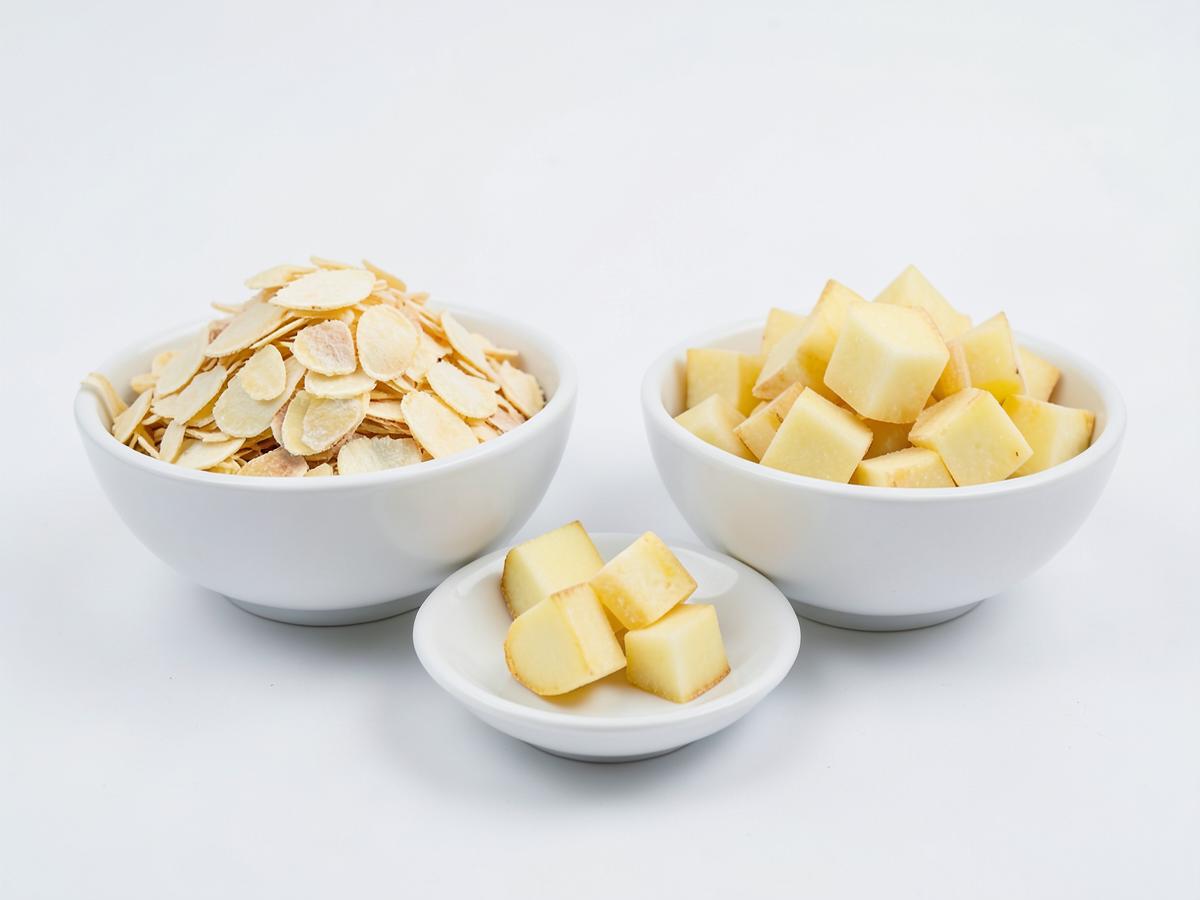 Dehydrated potato flakes and diced dried potato in white bowls